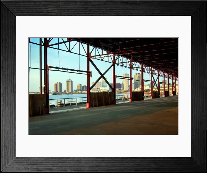 Framed Print : The skyline of New Orleans is visible thru the steel frame of an old factory building located in the newly developed Crescent Park on the banks of the Mississippi River in New Orleans. Louisiana, USA