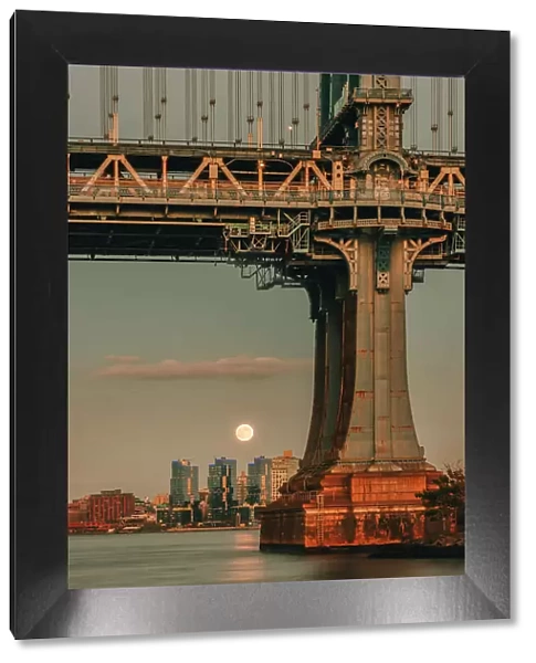 USA, New York City, view of the Moon rising behind the Manhattan Bridge