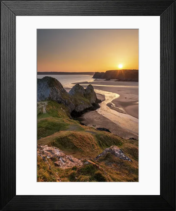 Framed Print : Golden sunset over Three Cliffs Bay on the Gower Peninsula, South Wales, UK. Spring (March) 2022
