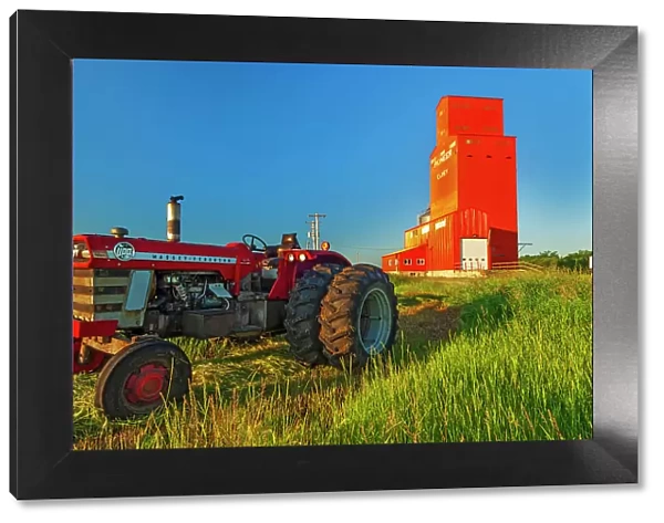 Grain elevator and tractor at sunrise. Carey, Manitoba, Canada
