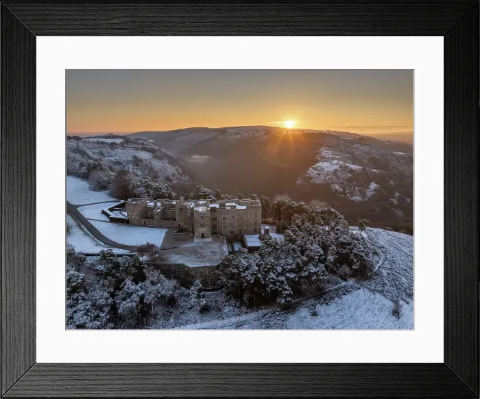 Framed Print : Sunrise over snow covered Castle Drogo on a chill winter morning, Dartmoor National Park, Devon, England. Winter (December) 2023
