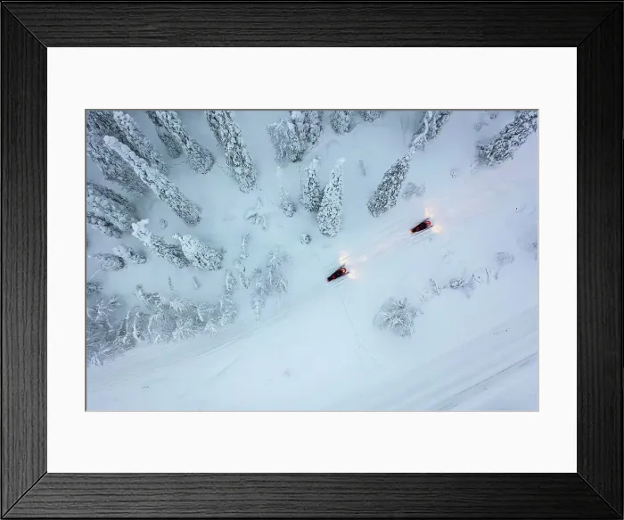Framed Print : Aerial of snowmobiles on road through snow-covered forest, Kuusamo, Finland Framed Print : Aerial of snowmobiles on road through snow-covered forest, Kuusamo, Finland