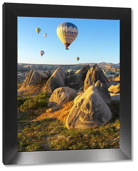 Aerial view of hot air balloon over rock formations at sunrise, Goreme, Goreme Historical National Park, Nevsehir District, Nevsehir Province, UNESCO, Cappadocia, Central Anatolia Region, Turkey