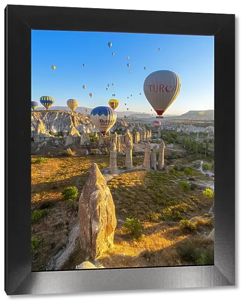 Rock formations in Love Valley and hot air balloons at sunrise, Goreme, Goreme Historical National Park, Nevsehir District, Nevsehir Province, UNESCO, Cappadocia, Central Anatolia Region, Turkey