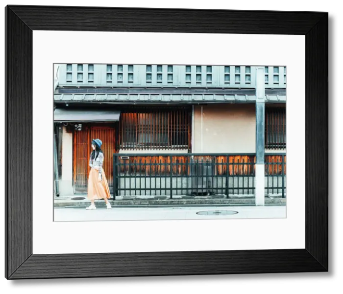 Framed Print : Japanese girl in front of a typical traditional building in Kyoto