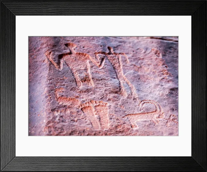 Framed Print : Ancient prehistoric petroglyphs on a rock of the Wadi Rum desert, Aqaba, Jordan. Declared a UNESCO World Heritage Site since 2011