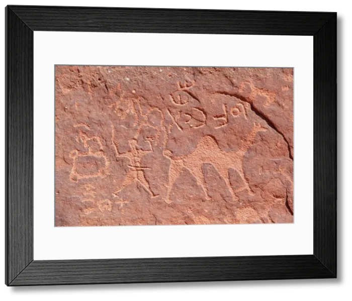 Framed Print : Ancient prehistoric petroglyphs on a rock of the Wadi Rum desert, Aqaba, Jordan, Middle East. Declared a UNESCO World Heritage Site since 2011