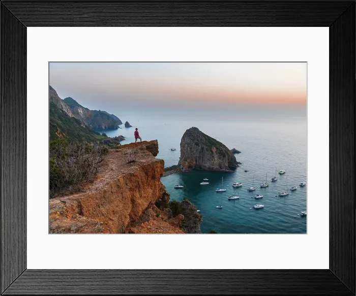Framed Print : Man stands on top of the cliff above the bay of Palmarola, Ponza municipality, Pontine archipelago, Latina province, Tyrrhenian Sea, Italy (MR)