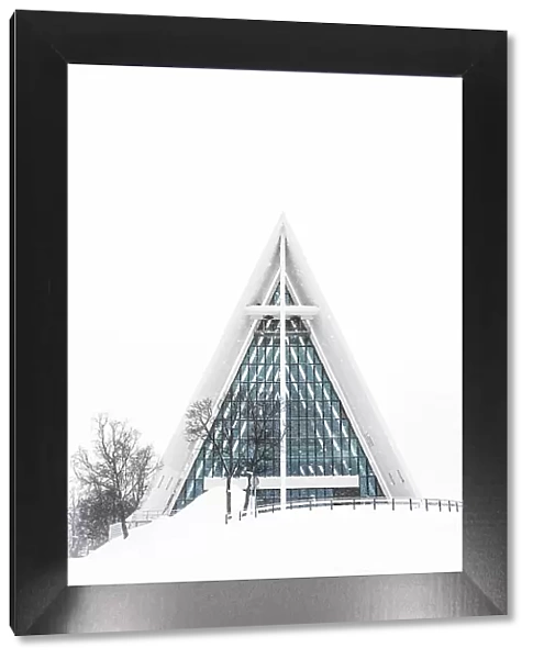 Snowy facade of the Arctic Cathedral decorated with glass windows, Tromso, Norway