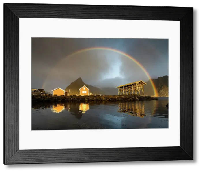 Framed Print : Fishermen cabins under a dramatic cloudy sky with rainbow at dawn, Sakrisoy, Reine, Nordland county, Lofoten Islands, Norway Framed Print : Fishermen cabins under a dramatic cloudy sky with rainbow at dawn, Sakrisoy, Reine, Nordland county, Lofoten Islands, Norway