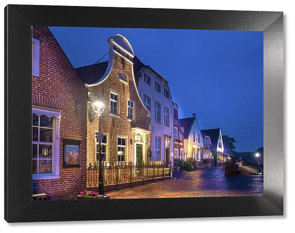 Historic brick houses at the harbor of Greetsiel at blue hour, East Frisia, Lower Saxony, Germany