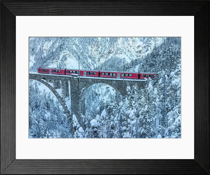 Framed Print : Aerial view of the Swiss red train traveling on Wiesen viaduct across snowy frozen woods, Davos, Graubunden canton, Switzerland Framed Print : Aerial view of the Swiss red train traveling on Wiesen viaduct across snowy frozen woods, Davos, Graubunden canton, Switzerland