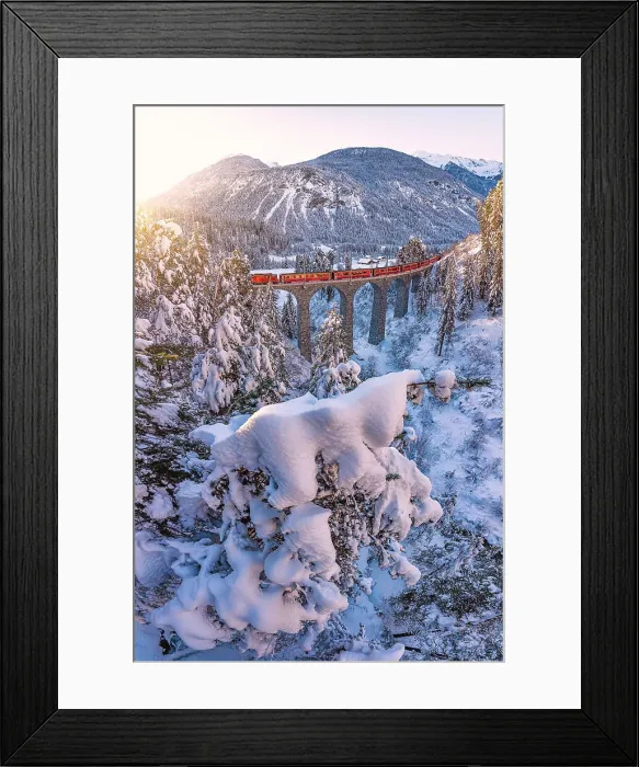 Framed Print : Swiss red train traveling across the frozen forest covered with snow after a blizzard at dawn, Graubunden canton, Switzerland Framed Print : Swiss red train traveling across the frozen forest covered with snow after a blizzard at dawn, Graubunden canton, Switzerland