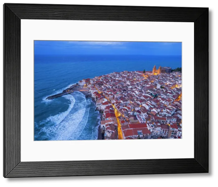 Framed Print : Dusk above the red tile roofs of Cefalu with street lights on and rough sea, aerial view, Cefalu, Palermo province, Tyrrhenian sea, Sicily, Italy Framed Print : Dusk above the red tile roofs of Cefalu with street lights on and rough sea, aerial view, Cefalu, Palermo province, Tyrrhenian sea, Sicily, Italy