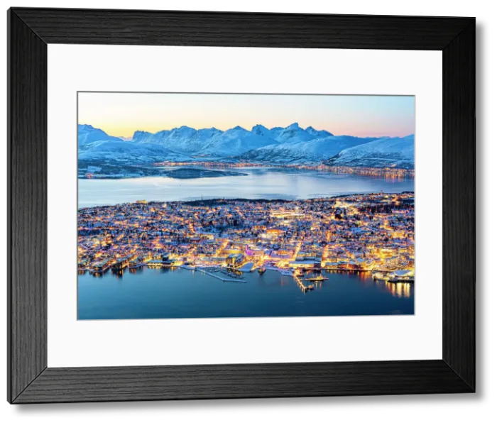 Framed Print : Dusk over snowy mountains surrounding the illuminated Tromso city and harbor seen from Fjellheisen cable car viewpoint, Norway Framed Print : Dusk over snowy mountains surrounding the illuminated Tromso city and harbor seen from Fjellheisen cable car viewpoint, Norway