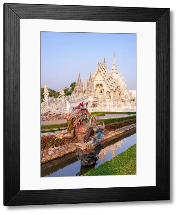 Framed Print : Bizarre statue of a dragon in the canals of lush gardens surrounding the Wat Rong Khun (White Temple), Chiang Rai, Thailand Framed Print : Bizarre statue of a dragon in the canals of lush gardens surrounding the Wat Rong Khun (White Temple), Chiang Rai, Thailand