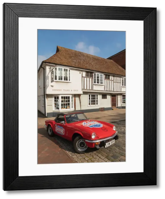Framed Print : England, Kent, Faversham, Annual Festival of Transport, Shepherd Neame Vintage Triumph Spitfire Car in Front of The Brewery Shop and Offices Framed Print : England, Kent, Faversham, Annual Festival of Transport, Shepherd Neame Vintage Triumph Spitfire Car in Front of The Brewery Shop and Offices
