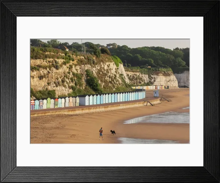Framed Print : England, Kent, Broadstairs, Stone Bay, Long Row of Colourful Beach Huts and Dog Walker Framed Print : England, Kent, Broadstairs, Stone Bay, Long Row of Colourful Beach Huts and Dog Walker