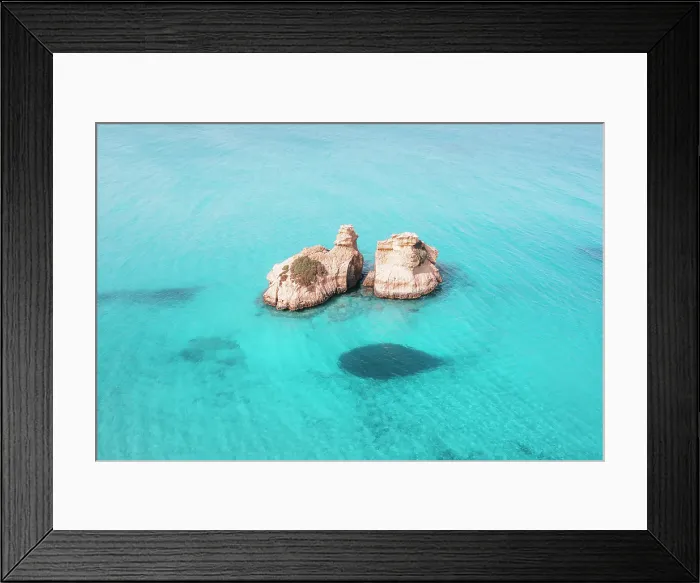 Framed Print : Aerial view of two rock formations in crystal-clear turquoise waters, located off the coast of Salento, Puglia, Italy. Two Sisters
