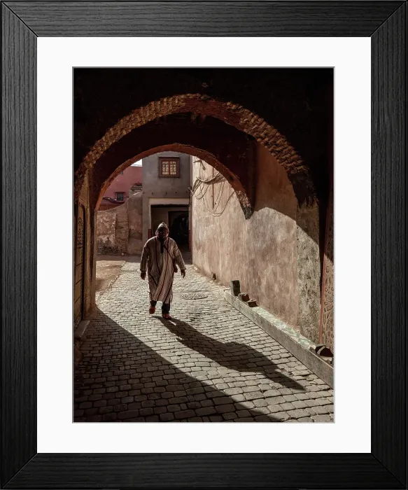 Framed Print : Local man in djellaba, walking through an archway on cobbled street, Medina, Marrakech, Morocco Framed Print : Local man in djellaba, walking through an archway on cobbled street, Medina, Marrakech, Morocco