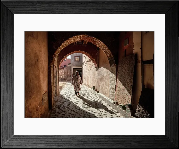 Framed Print : Local man in djellaba, walking through an archway on cobbled street, Medina, Marrakech, Morocco