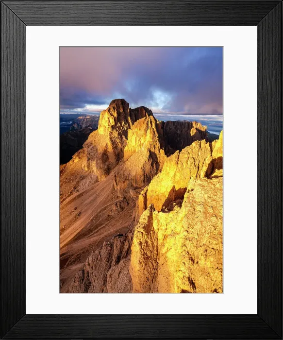 Framed Print : Dramatic clouds over Sassolungo rock pinnacles lit by sunset in autumn, helicopter view, Val di Fassa, Dolomites, Italy