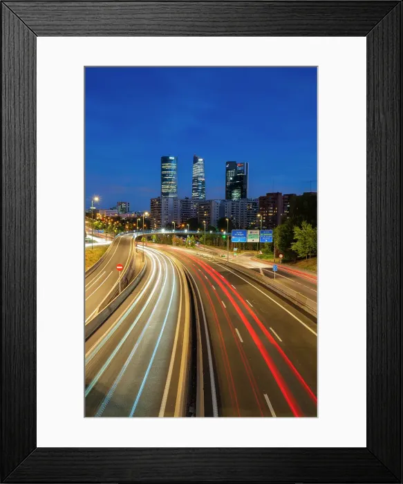 Framed Print : Car light trails on urban highway with Four Towers Business district in Paseo de la Castellana at twilight, Madrid, Spain Framed Print : Car light trails on urban highway with Four Towers Business district in Paseo de la Castellana at twilight, Madrid, Spain