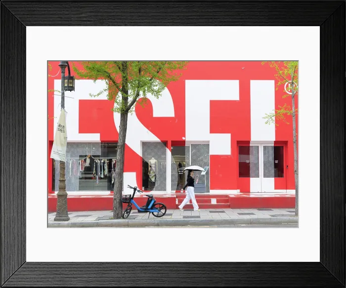 Framed Print : Woman walking past shop in Itaewon Dong area, Seoul, South Korea Framed Print : Woman walking past shop in Itaewon Dong area, Seoul, South Korea