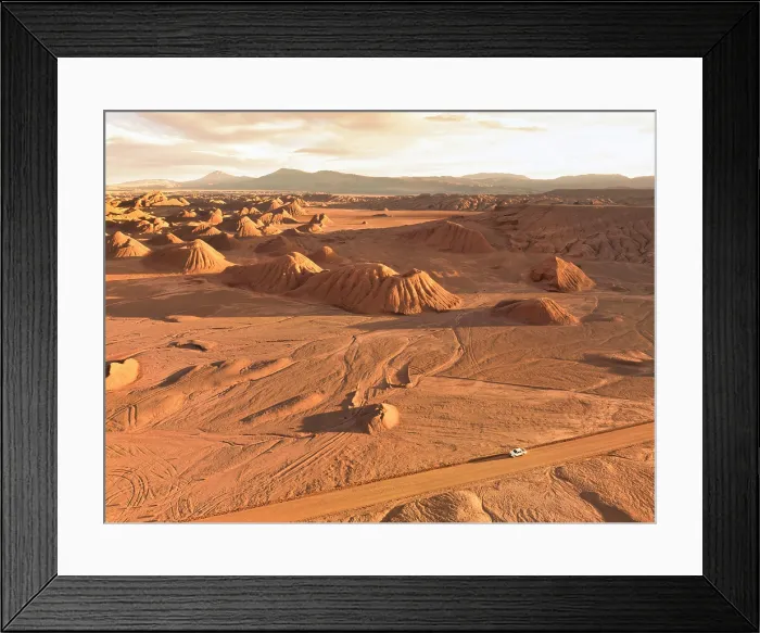 Framed Print : Aerial view of a 4x4 off-road vehicle on a dirty road in 'Los Colorados' at sunset, Devil Desert (Labyrinth Desert), Puna de Atacama, Tolar Grande, Salta, Argentina