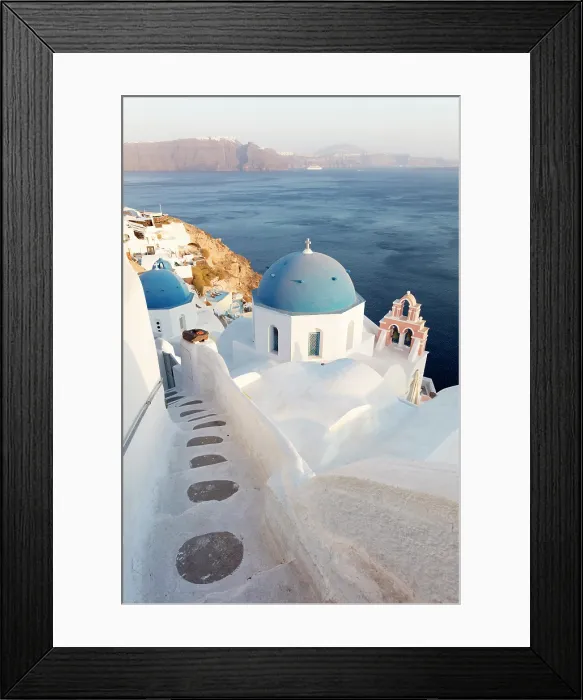 Framed Print : Blue domed churches, white-washed houses and steps with caldera view in the distance, Oia, Santorini, Cyclades Islands, Greece Framed Print : Blue domed churches, white-washed houses and steps with caldera view in the distance, Oia, Santorini, Cyclades Islands, Greece