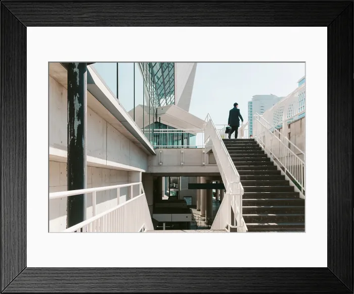 Framed Print : Yokohama businessman ascends stairs to modern building, symbolizing ambition and urban life Framed Print : Yokohama businessman ascends stairs to modern building, symbolizing ambition and urban life