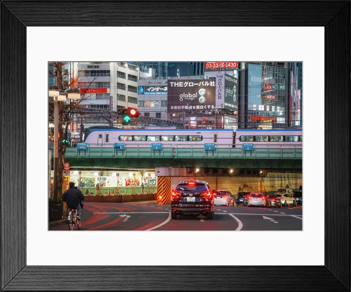 Framed Print : Japan, Tokyo, Train passing over road with cars and cyclist at dusk