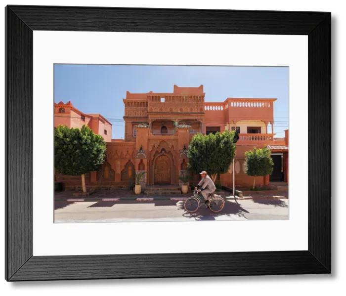 Framed Print : Cyclist passing in front of ornate riad, Ouarzazate, Morocco Framed Print : Cyclist passing in front of ornate riad, Ouarzazate, Morocco
