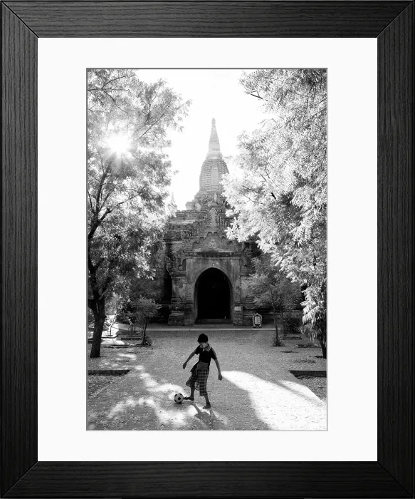 Framed Print : Young boy playing football outside an anciuent temple, Bagan, Myanmar Framed Print : Young boy playing football outside an anciuent temple, Bagan, Myanmar