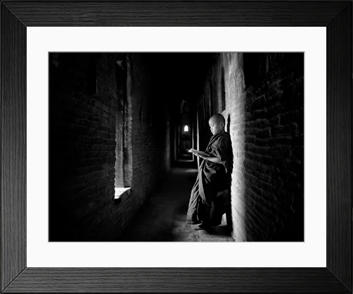Framed Print : Novice Buddhist monk reading Buddhist scriptures in the light of a window in one of the many temples of Bagan, Myanmar (Burma) Framed Print : Novice Buddhist monk reading Buddhist scriptures in the light of a window in one of the many temples of Bagan, Myanmar (Burma)