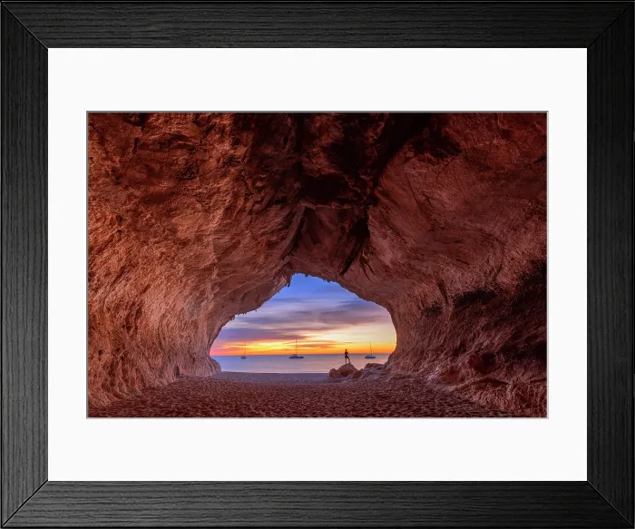 Framed Print : Lonely person looks colors of the sunrise inside the sea cave on the beach of Cala Luna, Baunei, Ogliastra province, Sardinia, Italy (MR) Framed Print : Lonely person looks colors of the sunrise inside the sea cave on the beach of Cala Luna, Baunei, Ogliastra province, Sardinia, Italy (MR)