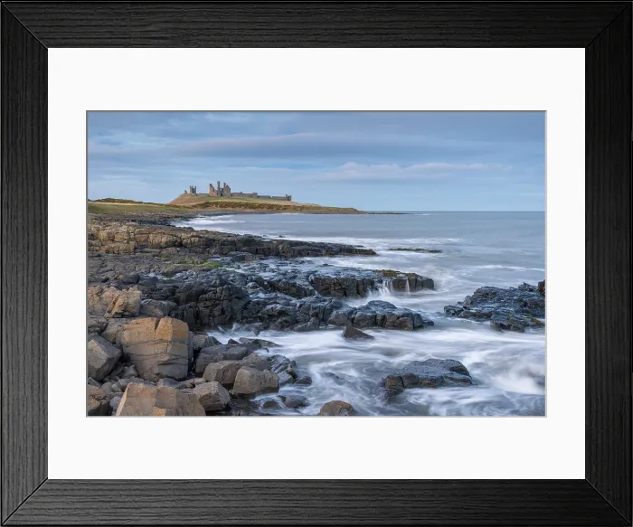 Framed Print : Dunstanburgh Castle above the rocky coastline near Craster, Northumberland, England. Winter (March) 2025