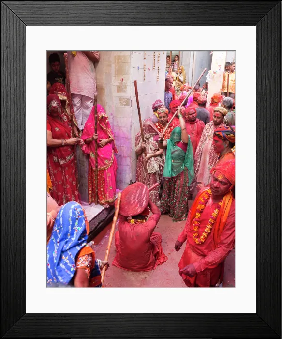 Framed Print : India, Uttar Pradesh, Mathura, Barsana, A man protects himself with a shield from women with sticks during the Lathmar Holi Festival Framed Print : India, Uttar Pradesh, Mathura, Barsana, A man protects himself with a shield from women with sticks during the Lathmar Holi Festival