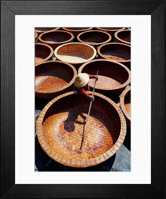 Framed Print : Worker applying oil to waterproof bamboo basket boats, Tuy An, Phu Yen province, Vietnam. (MR)