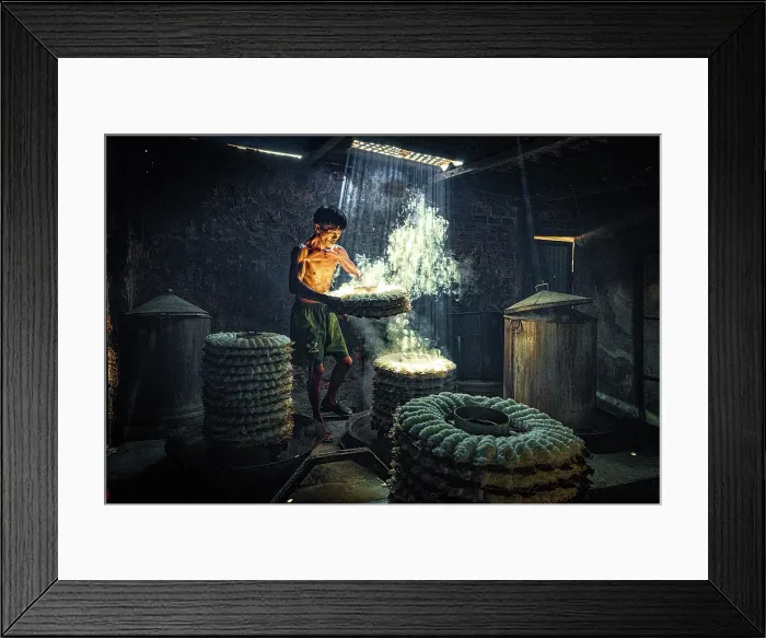 Framed Print : Man steaming traditional rice cakes in an old kitchen, Phan Thiet, Binh Thuan Province, Vietnam. (MR)