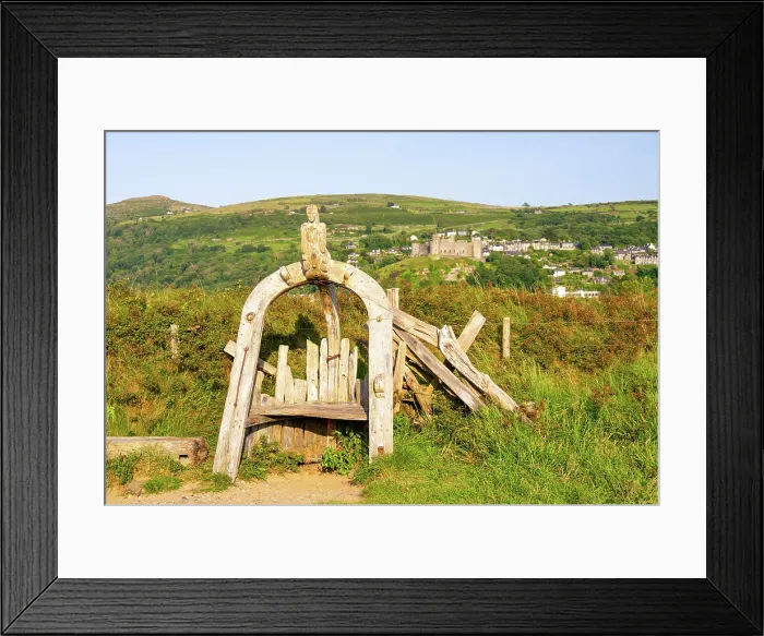 Framed Print : Wooden storytelling chair from 'Meirion's Story', a local legend and trail in Harlech, with Harlech Castle (Castell Harlech) in the background, Harlech, Gwynedd Framed Print : Wooden storytelling chair from 'Meirion's Story', a local legend and trail in Harlech, with Harlech Castle (Castell Harlech) in the background, Harlech, Gwynedd