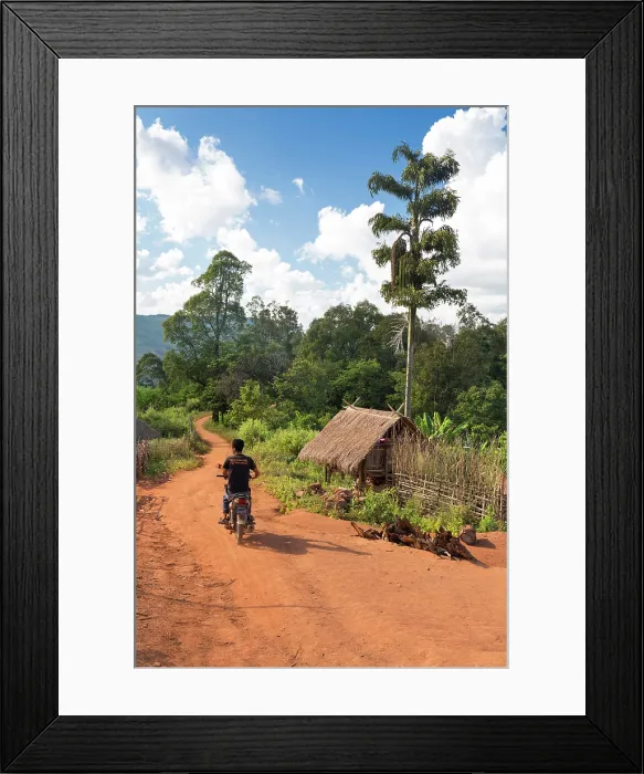 Framed Print : Myanmar, Burma, Shan, Keng Tung, a motorcyclist rides through a village near Keng Tung Framed Print : Myanmar, Burma, Shan, Keng Tung, a motorcyclist rides through a village near Keng Tung