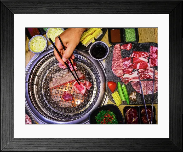 Framed Print : Hand placing meat on a grill with vegetables and sauces, Vietnam Framed Print : Hand placing meat on a grill with vegetables and sauces, Vietnam
