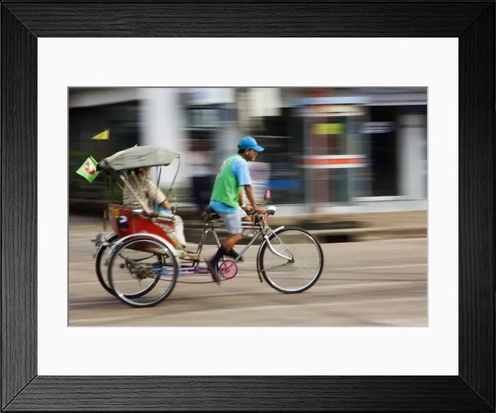 Framed Print : Thailand, Sakhon Nakhon, Sakhon Nakhon. A saamlaw (three wheeled pedicab) driver peddles his passengers through the streets of