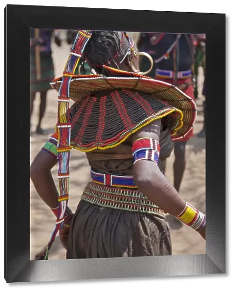 A Pokot woman in traditional attire dances to celebrate an Atelo ceremony