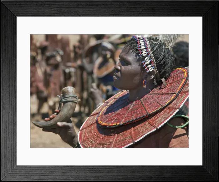Framed Print : During a Ngetunogh ceremony, the mother of a Pokot initiate sings and dances holding the cowhorn container she used to smear fat over the masks of her son and other boys as Framed Print : During a Ngetunogh ceremony, the mother of a Pokot initiate sings and dances holding the cowhorn container she used to smear fat over the masks of her son and other boys as