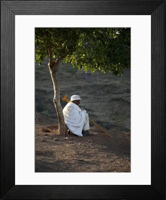 Framed Print : Ethiopia, Lalibela. An old man rests beneath a tree in the early morning light Framed Print : Ethiopia, Lalibela. An old man rests beneath a tree in the early morning light