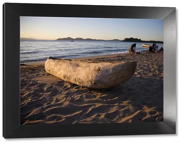 Malawi, Monkey Bay. An old dug-out canoe pulled up on to the beach of Lake Malawi