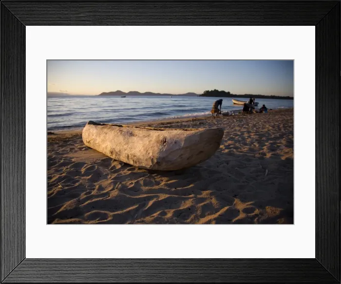 Framed Print : Malawi, Monkey Bay. An old dug-out canoe pulled up on to the beach of Lake Malawi