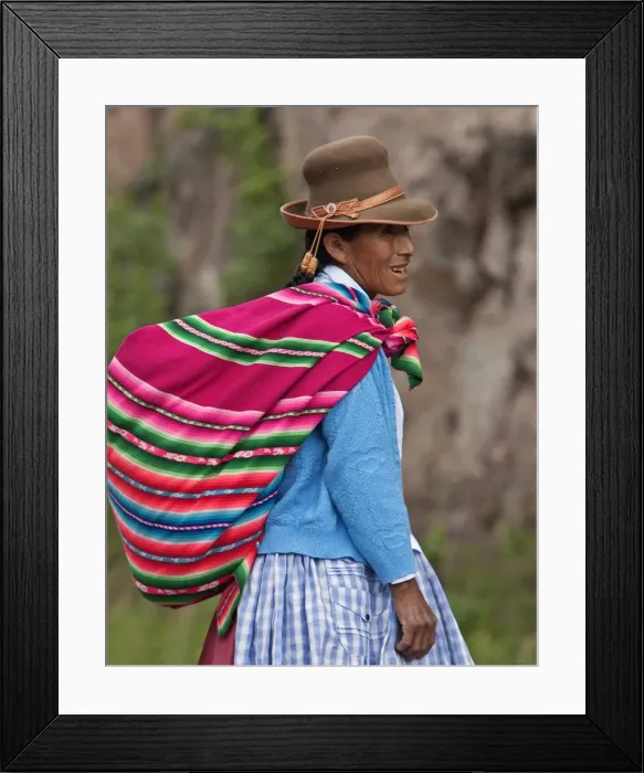 Framed Print : Peru. An Indian woman wearing a felt hat carries her farm produce to market in a brightly coloured blanket